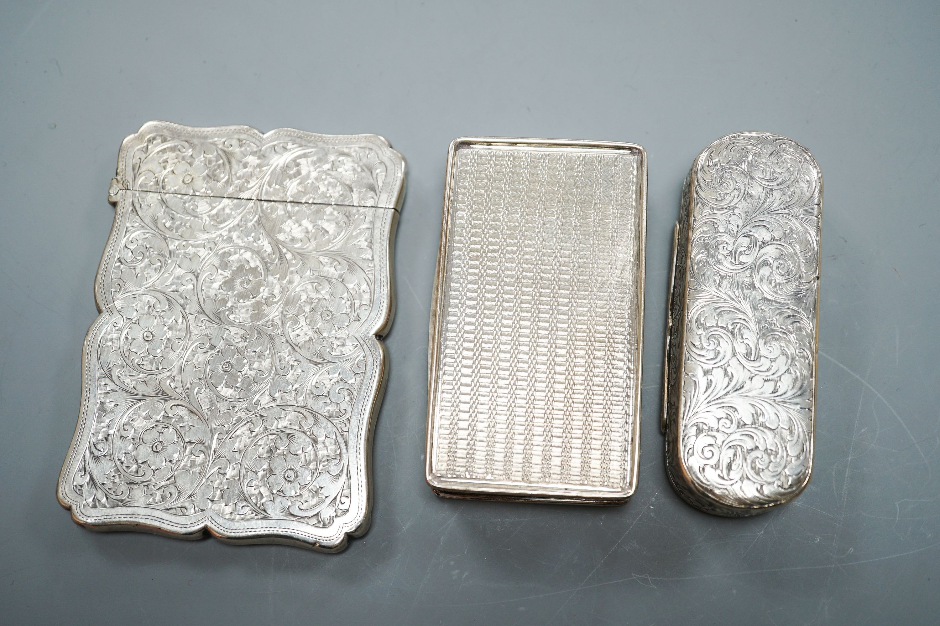 Two English silver snuff boxes, rectangular Birmingham, 1827, 81mm and Edward Smith oval, Birmingham, 1851 together with an Edwardian silver card case, Goldsmiths & Silversmiths, London, 1902.